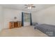 Bright bedroom featuring neutral carpet, a ceiling fan, and a window with blue curtains at 9230 Windygap Rd, Charlotte, NC 28278