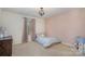 Comfortable bedroom with a pastel pink wall and decor, featuring neutral carpet at 9230 Windygap Rd, Charlotte, NC 28278