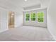 Bright bedroom boasts three large windows and access to an ensuite bathroom with glass shower at 10119 Mamillion Dr, Huntersville, NC 28078