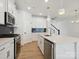 Modern kitchen with white cabinets, an island, stainless appliances, and sleek black backsplash at 10119 Mamillion Dr, Huntersville, NC 28078