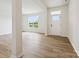 Bright and open living room with wood-look flooring, a large window, and a modern white front door at 10119 Mamillion Dr, Huntersville, NC 28078
