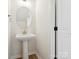 Powder room featuring a pedestal sink and modern fixtures, next to a door at 10119 Mamillion Dr, Huntersville, NC 28078