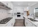 Modern kitchen with white cabinets, stainless steel appliances, and hexagon tile backsplash at 1182 Lost Cove Rd, Indian Land, SC 29707