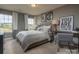 Cozy bedroom with a window and gray bedding at 12028 Grinstead Ln # 292, Charlotte, NC 28278