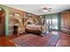 This spacious main bedroom features a red rug, wooden walls, and unique wooden furniture at 1262 Ring Tail Rd, Claremont, NC 28610