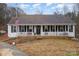 White ranch house with front porch and American flag at 127 Halifax Ct, Gastonia, NC 28056