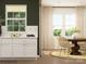 Kitchen breakfast nook with white cabinets, a round wooden table, and wicker chairs at 149 Dogwood Grove Pl, Troutman, NC 28166