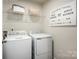 Bright laundry room with washer, dryer, and shelving at 1705 Gutter Branch Dr, Charlotte, NC 28216