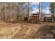 A wooden playset in a large backyard surrounded by tall trees at 1721 Gold Hill Rd, Concord, NC 28025