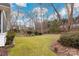 A view of the backyard with a sprawling lawn, framed by mature trees and partial borders at 17521 Cambridge Grove Dr, Huntersville, NC 28078