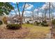 Landscaped backyard with a lush lawn, mature trees, hardscape, and screened-in porch at 17521 Cambridge Grove Dr, Huntersville, NC 28078