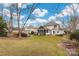 Wide shot of the lawn featuring a screened-in porch, hardscape brick patio, and lush landscaping at 17521 Cambridge Grove Dr, Huntersville, NC 28078