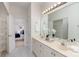 Bright bathroom with double sinks, a large mirror, and a view to the Primary bedroom at 17521 Cambridge Grove Dr, Huntersville, NC 28078