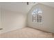 A well-lit bedroom features a large arched window and neutral carpeting at 17521 Cambridge Grove Dr, Huntersville, NC 28078