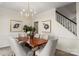 Dining room with a modern chandelier and view of the staircase with wood and black railing at 17521 Cambridge Grove Dr, Huntersville, NC 28078