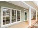 Inviting front porch of home with white pillars and green siding at 17521 Cambridge Grove Dr, Huntersville, NC 28078