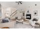 Bright living room featuring a fireplace, open staircase, neutral decor, and a ceiling fan at 17521 Cambridge Grove Dr, Huntersville, NC 28078