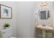 Charming powder room featuring a pedestal sink and decorative mirror at 17521 Cambridge Grove Dr, Huntersville, NC 28078