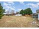 A large, mostly clear backyard on a sunny day has some trees and a shed at 1876 Rollins Dr, Catawba, NC 28609