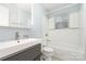 A bathroom with a vanity sink, a shower-tub, and white tiled walls at 1876 Rollins Dr, Catawba, NC 28609