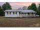 A white home with a metal roof, a covered porch, and a large front yard at 1876 Rollins Dr, Catawba, NC 28609