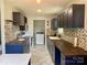 Modern kitchen with dark blue cabinets, butcher block countertops, and mosaic backsplash at 1876 Rollins Dr, Catawba, NC 28609