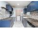 Updated kitchen features blue cabinets, modern countertops, stylish backsplash and white marble floors at 1876 Rollins Dr, Catawba, NC 28609