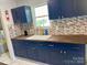 Kitchen features dark blue cabinets, wood countertops, and a mosaic tile backsplash at 1876 Rollins Dr, Catawba, NC 28609