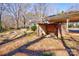 Backyard featuring an open carport and outdoor room with brick detail, all nestled in a leafy landscape at 1900 E Dixon Blvd, Shelby, NC 28152