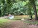 Backyard view to a dock and waterfront featuring mature trees and a shed at 198 Clouse Ln, Taylorsville, NC 28681