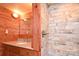 Bathroom with wood-paneled walls, a tiled shower, and granite vanity at 198 Clouse Ln, Taylorsville, NC 28681