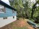 Exterior side view of blue house surrounded by trees; includes boat on shore at 198 Clouse Ln, Taylorsville, NC 28681