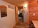 Hallway leads into a living room with wood-look floors, rustic decor, and wood trim throughout the home at 198 Clouse Ln, Taylorsville, NC 28681