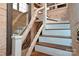 Unique staircase featuring wooden treads, white risers, and a rustic branch-style railing with rope accents and a decorative mirror at 198 Clouse Ln, Taylorsville, NC 28681