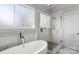 Bathroom with freestanding tub, marble tile, and glass shower at 2408 Rozzelles Ferry Rd, Charlotte, NC 28208