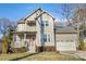 Two-story craftsman style home with red door, attached garage, and manicured lawn at 2408 Rozzelles Ferry Rd, Charlotte, NC 28208