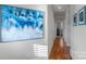 Bright hallway with hardwood floors and large art piece at 2408 Rozzelles Ferry Rd, Charlotte, NC 28208