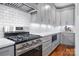 Modern gas range and gray cabinets in this stylish kitchen at 2408 Rozzelles Ferry Rd, Charlotte, NC 28208