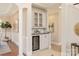 Home bar area features white cabinetry, granite countertop, and wine cooler at 2907 Cutter Ct, Waxhaw, NC 28173