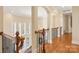 Hallway with arched doorways, hardwood floors, wooden railings with iron spindles, and bright natural light at 2907 Cutter Ct, Waxhaw, NC 28173