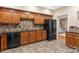 Well-equipped kitchen featuring dark appliances, wood cabinets, and tile backsplash at 2907 Cutter Ct, Waxhaw, NC 28173