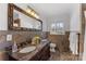 Elegant bathroom with double vanity, stone tile, and large mirror at 3019 Parkstone Dr, Charlotte, NC 28210