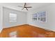 Simple bedroom with hardwood floors and two windows at 3019 Parkstone Dr, Charlotte, NC 28210