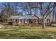 Brick ranch home with landscaped lawn and mature trees at 3019 Parkstone Dr, Charlotte, NC 28210