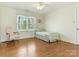 Cozy bedroom with hardwood floors, a ceiling fan, and a sunlit window with views of mature trees at 3041 Valencia Ter, Charlotte, NC 28211