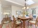 Sunny dining area with hardwood floors, skylight, and an open view into the kitchen at 3041 Valencia Ter, Charlotte, NC 28211