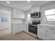 White kitchen with stainless steel appliances and hardwood floors at 400 E 27Th St, Kannapolis, NC 28083