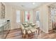 Bright dining area with a modern glass table, cream colored curtains, and wood flooring at 5057 Spratt Rd, York, SC 29745