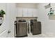 Practical laundry room features modern washer and dryer with white cabinets and neutral walls at 5057 Spratt Rd, York, SC 29745