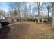 Large backyard with an in-ground pool, a black metal fence, and mature trees providing shade at 523 Fence Post Ln, Matthews, NC 28105